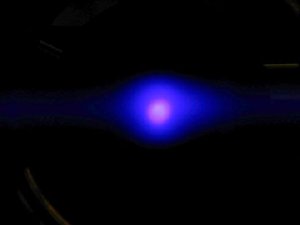 This photo shows about 1 million ytterbium atoms illuminated by a blue laser in an experimental atomic clock that holds the atoms in a lattice made of intersecting laser beams. The photo was taken with a digital camera through the window of a vacuum chamber. NIST is studying the possible use of ytterbium atoms in next-generation atomic clocks based on optical frequencies, which could be more stable and accurate than today
