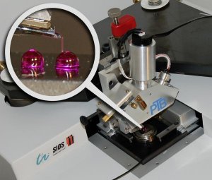 The micro probe used in the micro-nano CMM measures the form and the spacing of two reference spheres with diameters of two millimetres each. The figure shows a survey of the system and the proportions of measuring probe and measurement object in detail. (Credit: PTB)