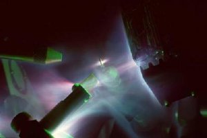 This is an image of the infrared laser (not seen, entering from left-hand side) interacting with a flat target (center), and the associated plasma production from the interaction on the various diagnostic instruments in the chamber. This is a time integrated image over five seconds. Credit: Joe Cowan and Kirk Flippo, LANL
