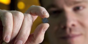 BYU prof Aaron Hawkins holds a tiny microchip that can detect viruses in fluid.