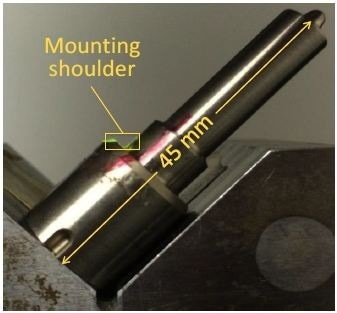 Photograph of fuel injector, with mounting shoulder region outlined in yellow.
