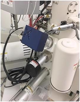 The compact Evactron E50 model fits among a forest of accessories on a crowded SEM chamber.