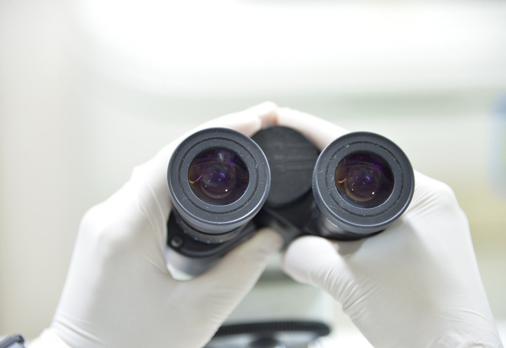 close-up of scientist hands with microscope, examining samples and liquid