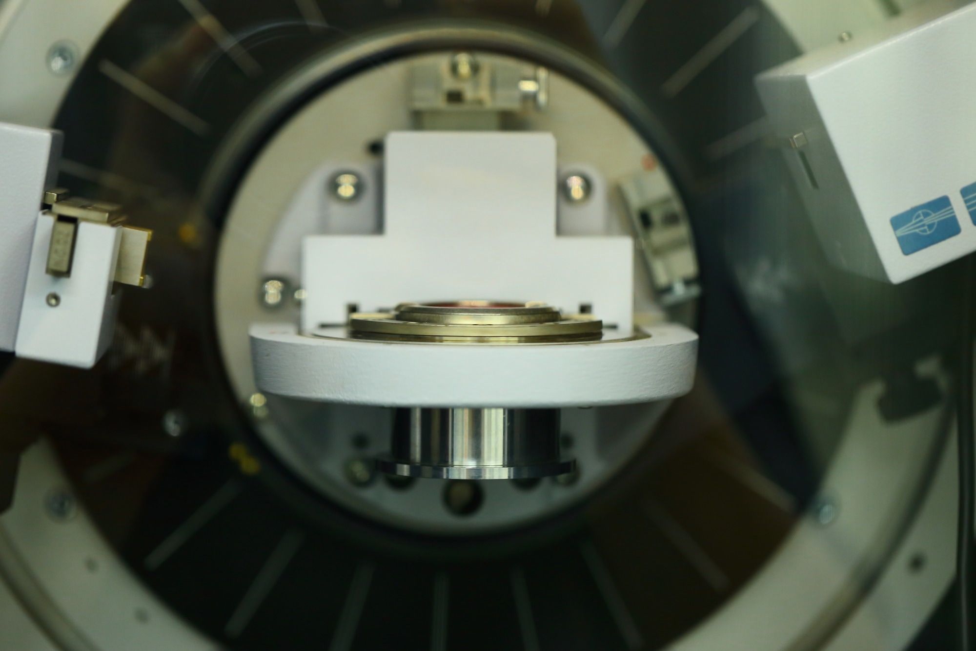 This image shows a close-up of an X-ray diffraction (XRD) machine or a similar advanced material characterization instrument, likely used for structural analysis in materials science. It depicts the sample stage and the X-ray source area of the equipment.