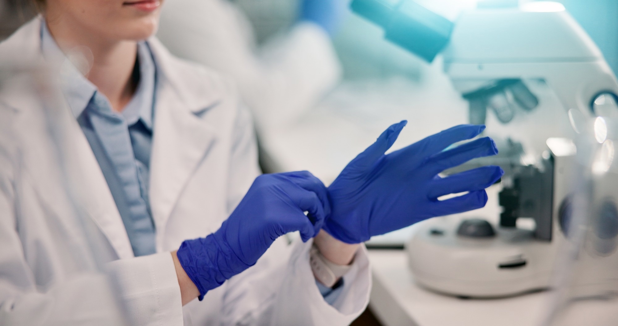 Researcher puts on protective gloves in a lab