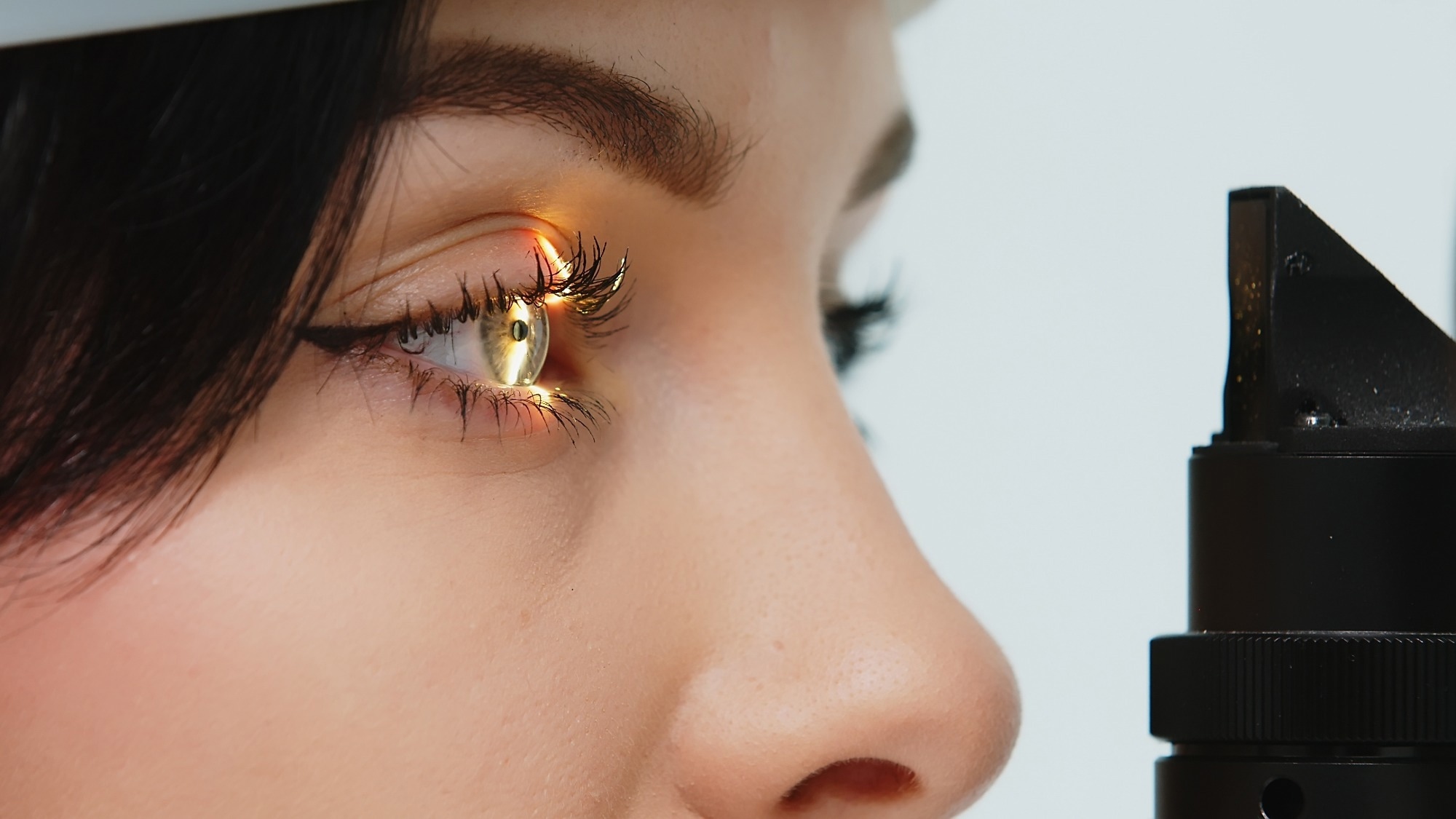 Close-up of a young woman having her vision tested on an ophthalmology diagnostic vision testing equipment.