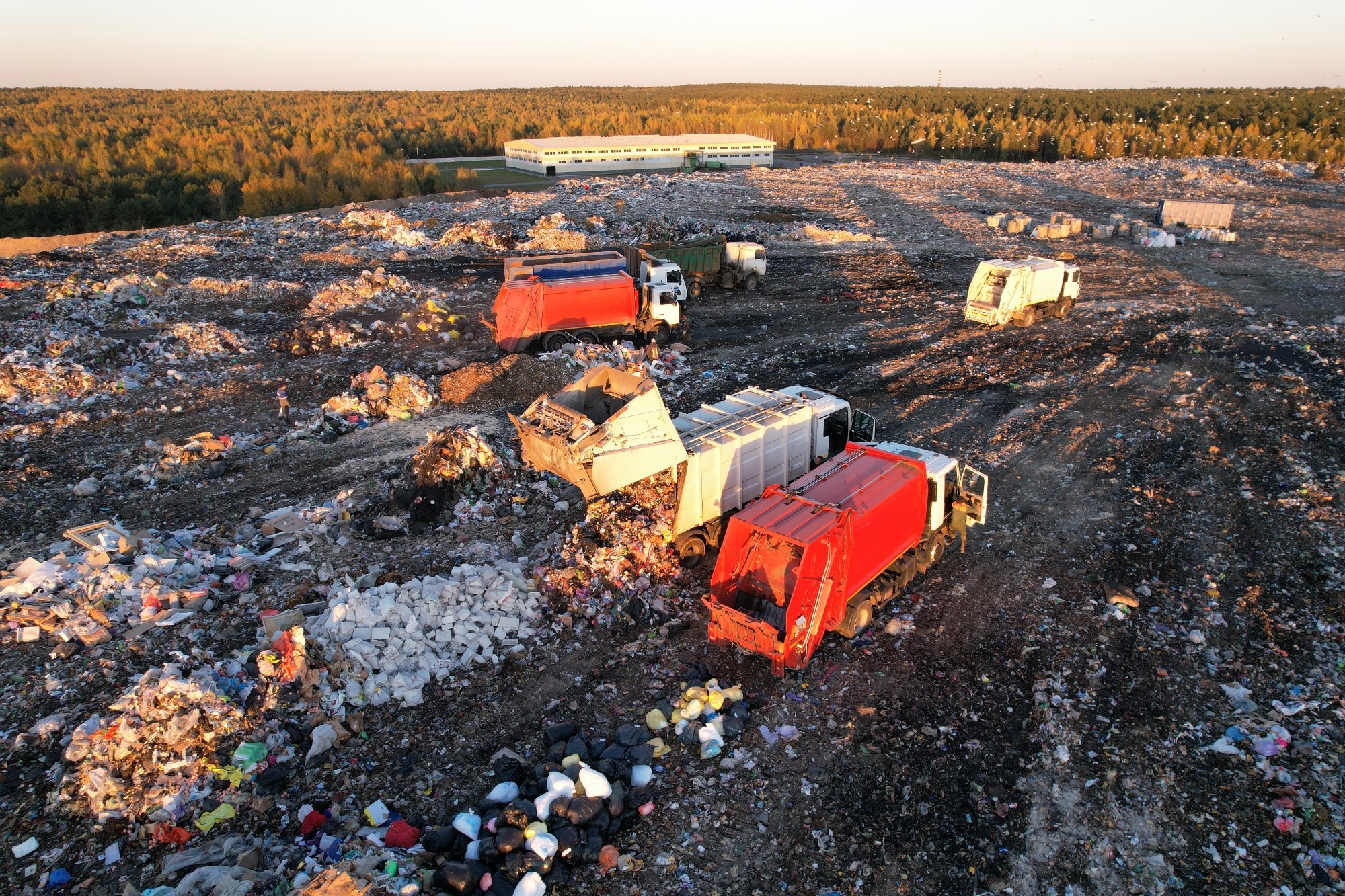 An aerial image of a landfill site with two red lorries parked amongst the rubbish.