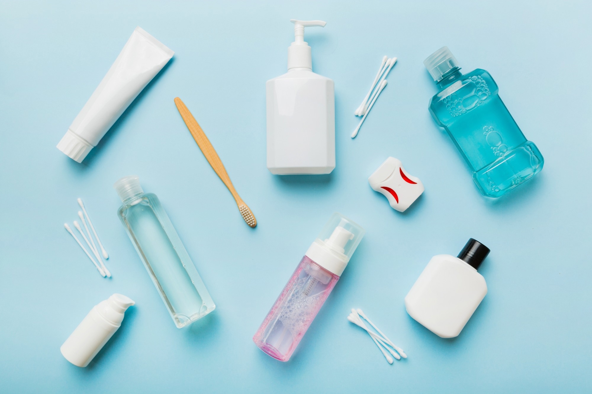 A variety of different cosmetics without branding against a light blue background.