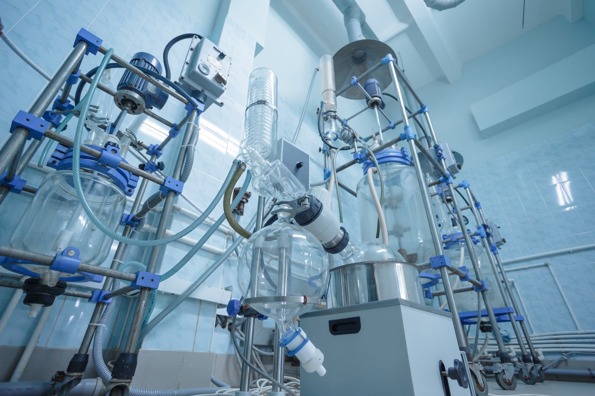 Industrial lab with large glass reactors and distillation equipment for scientific chemical research and pharmaceutical production
