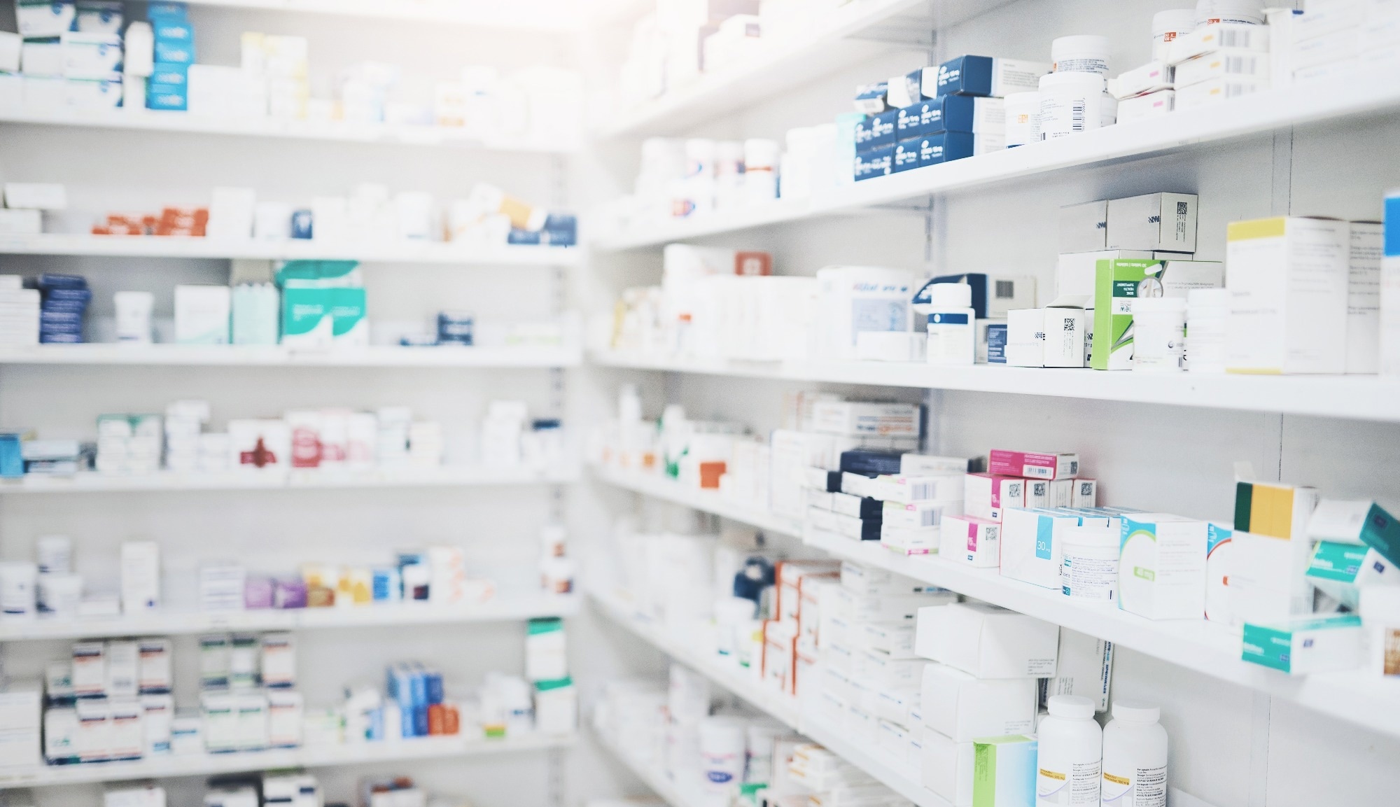 Pharmacy shelves with a prescription drugs lining the shelves.
