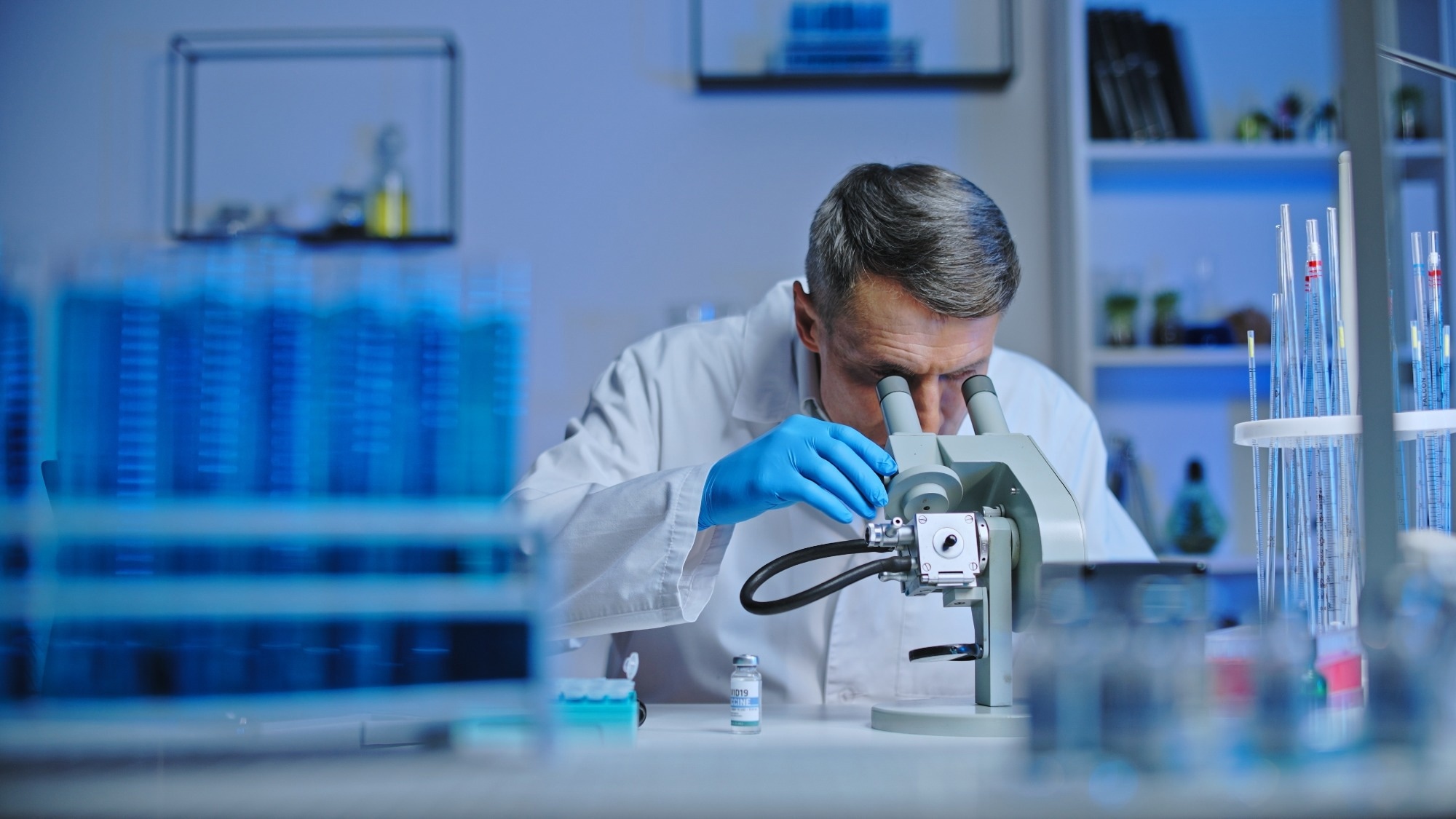 Scientist analyzing a material under a microscope.