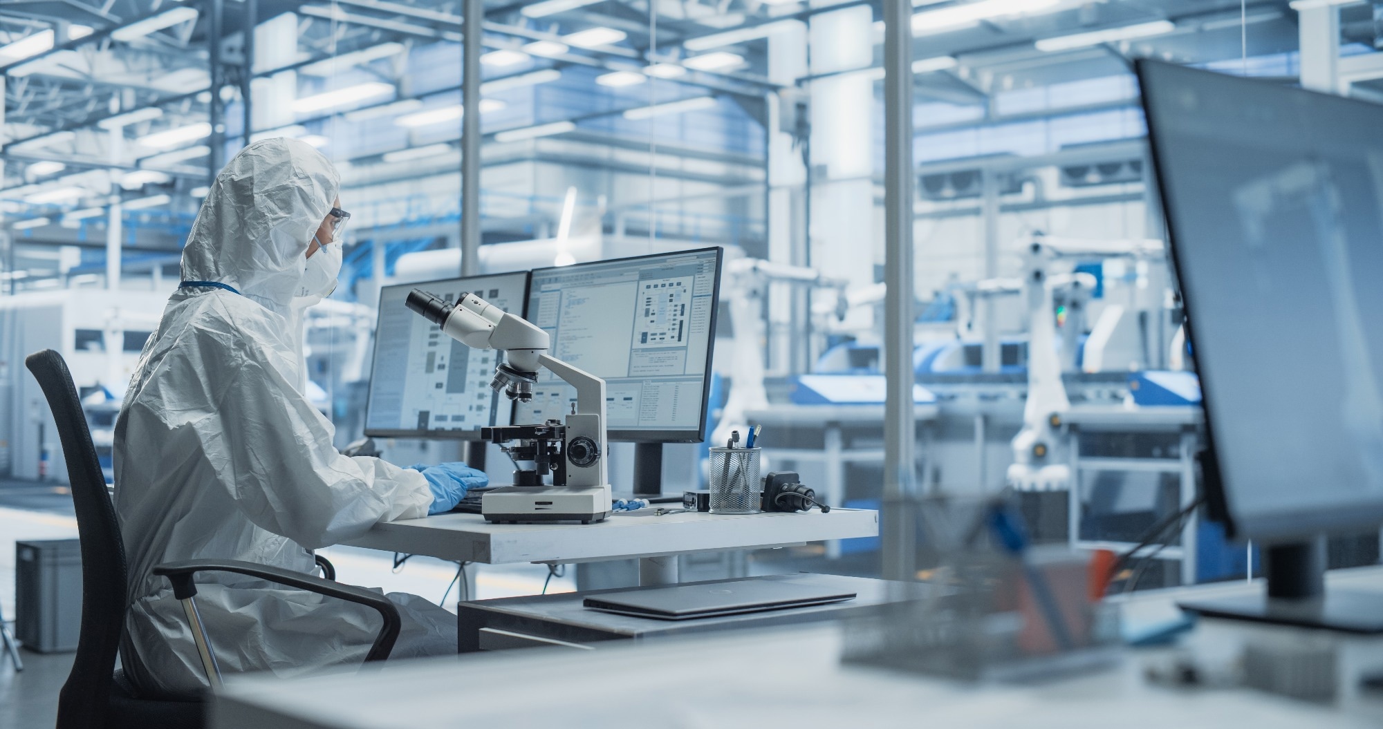 Scientist in ultra-clean research facility developing 2D materials.