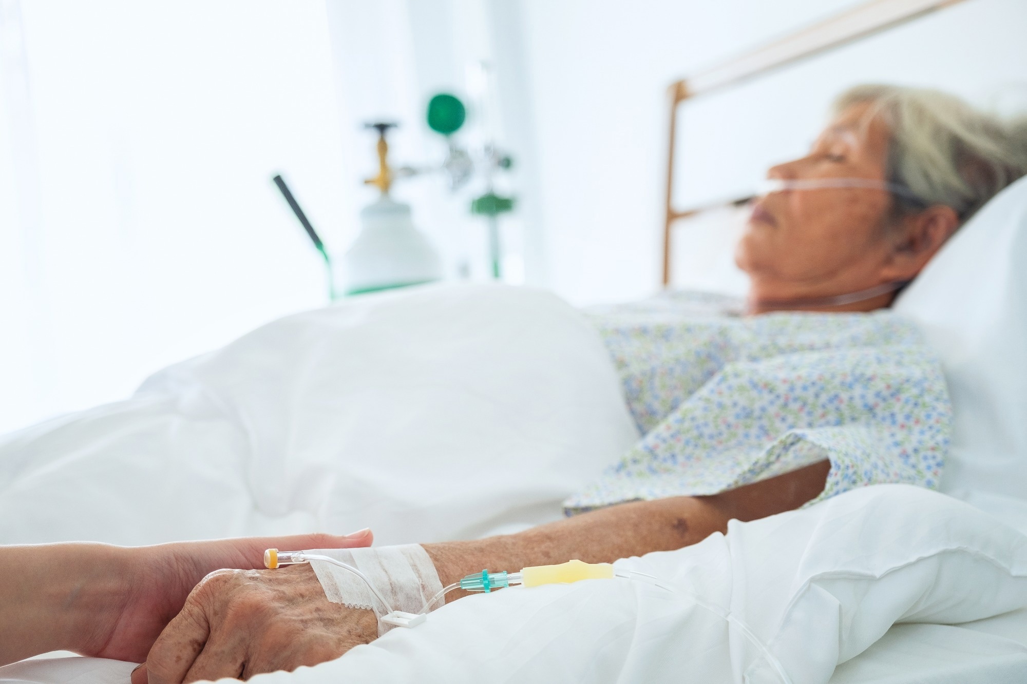 An elderly woman in a hospital bed recovering from a severe injury.