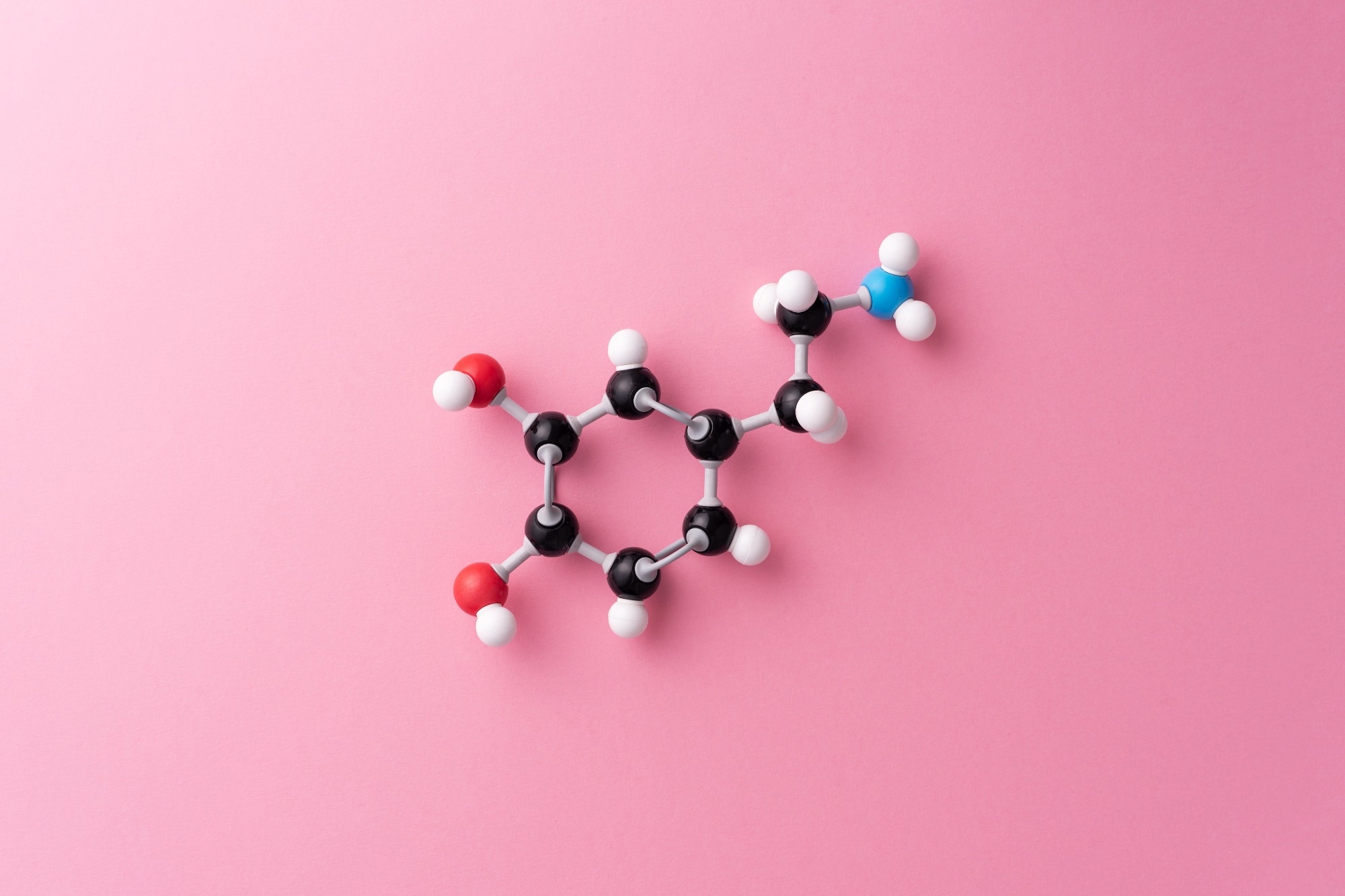 A dopamine molecule made of molymods against a pink background.