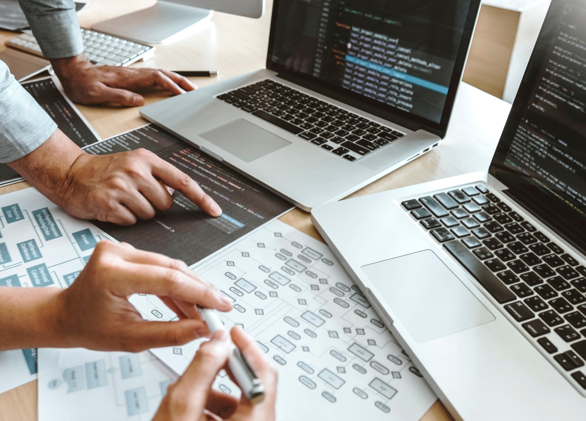 Two people discussing data management with two laptops.