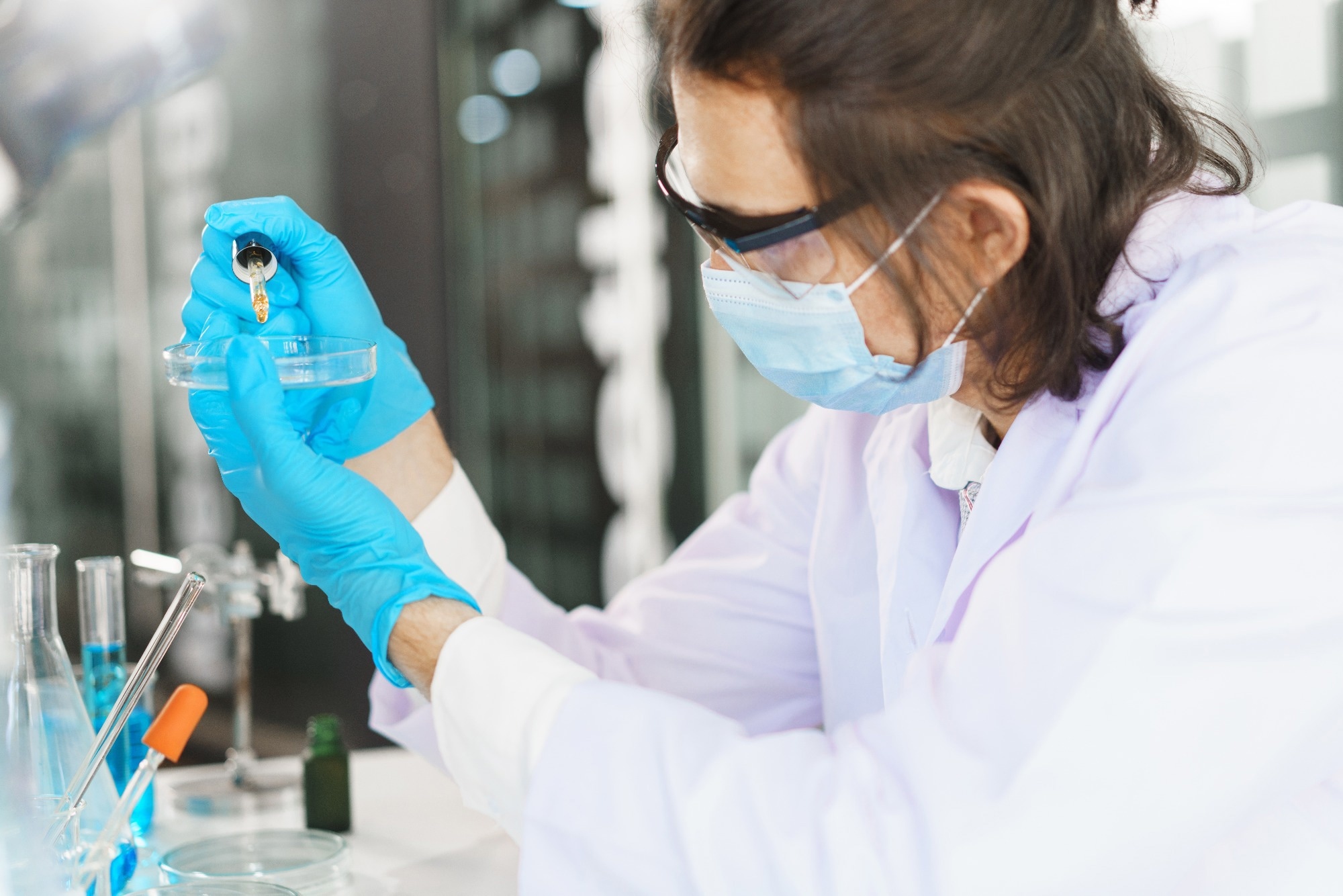 Scientist drop of solution into petri dish for research of drug.