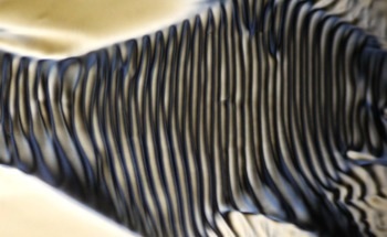 Stripes in a Flowing Liquid Crystal Suggest a Route to “Chiral” Fluids