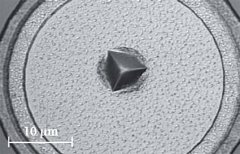Optical micrograph of a 200 mN nanoindentation performed on a circular bonding pad consisting of a 1 μm aluminium film deposited onto a Si substrate.